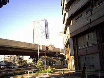 ヒルズの脇にて東京ミッドタウンを眺めるの図